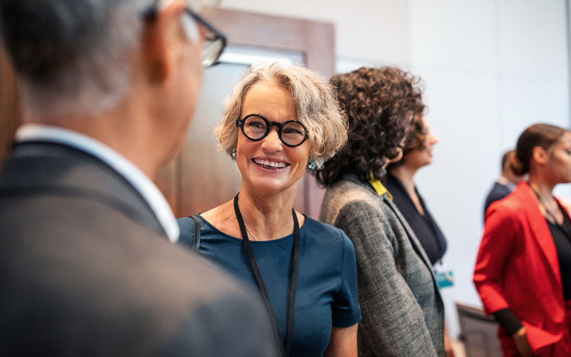 USC Distinguished Leaders Program unique approach - Policy and Social Good. Business professionals having a casual chat before a launch event.