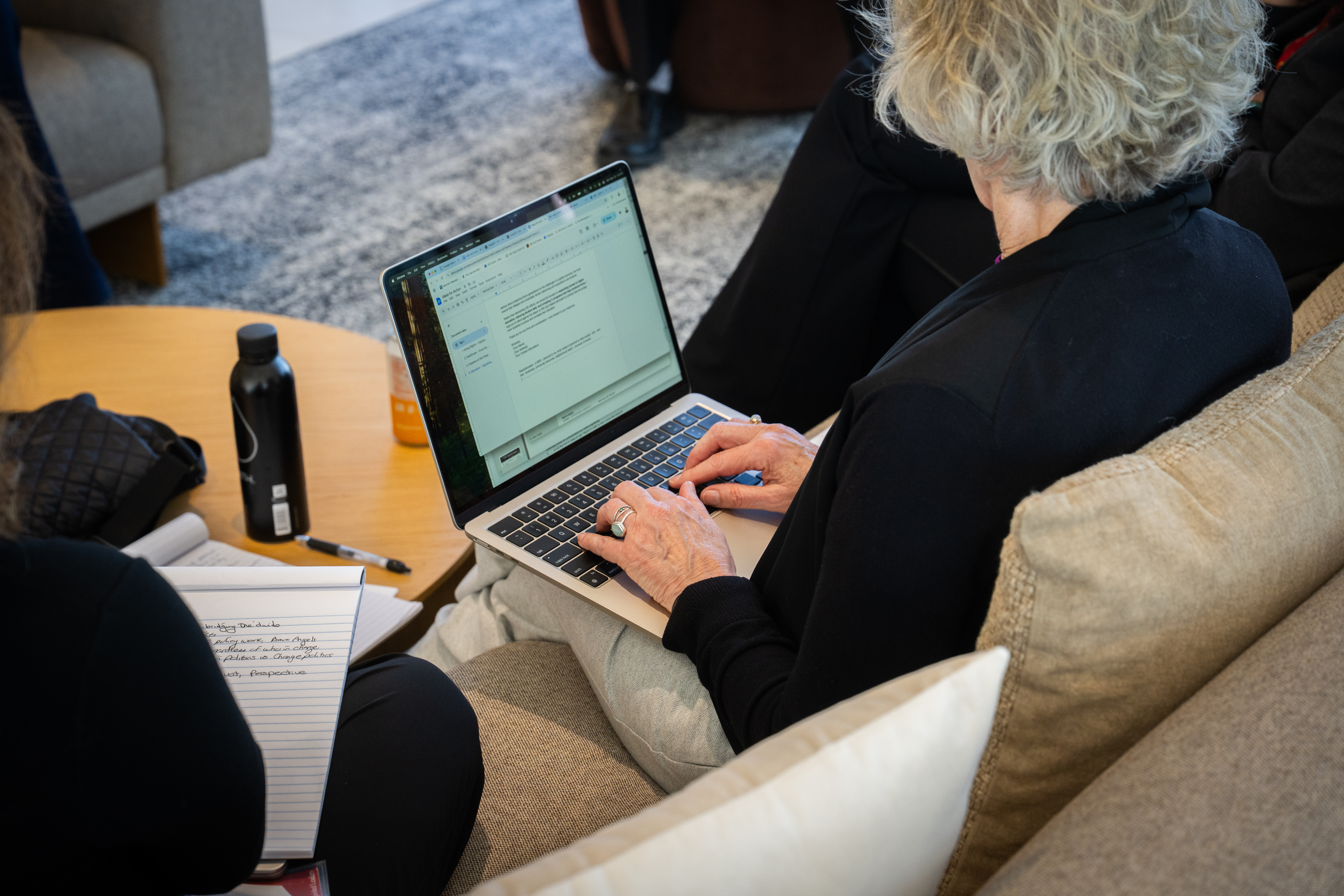 Person on laptop typing notes.