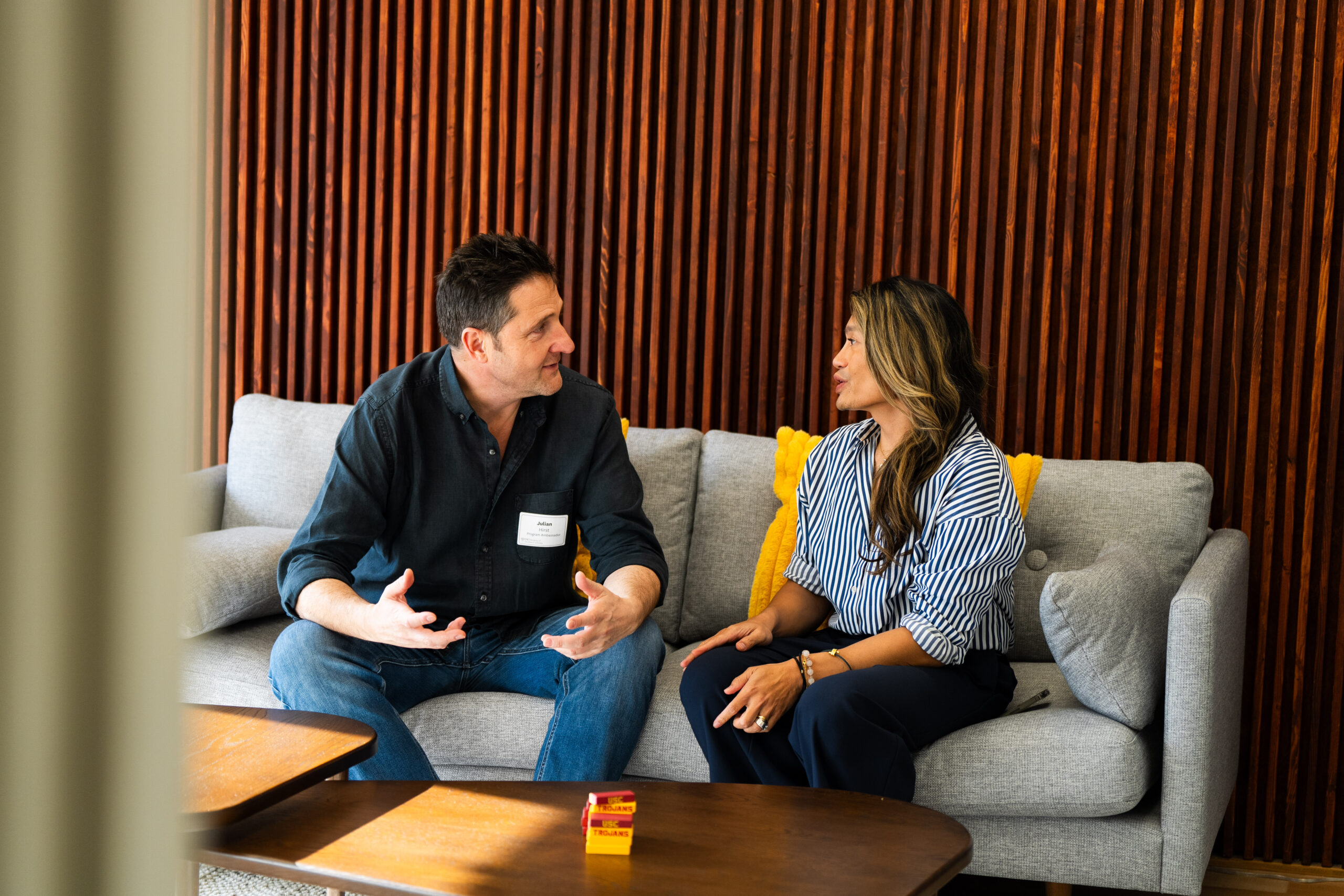 Two people chatting whilst sitting on a couch